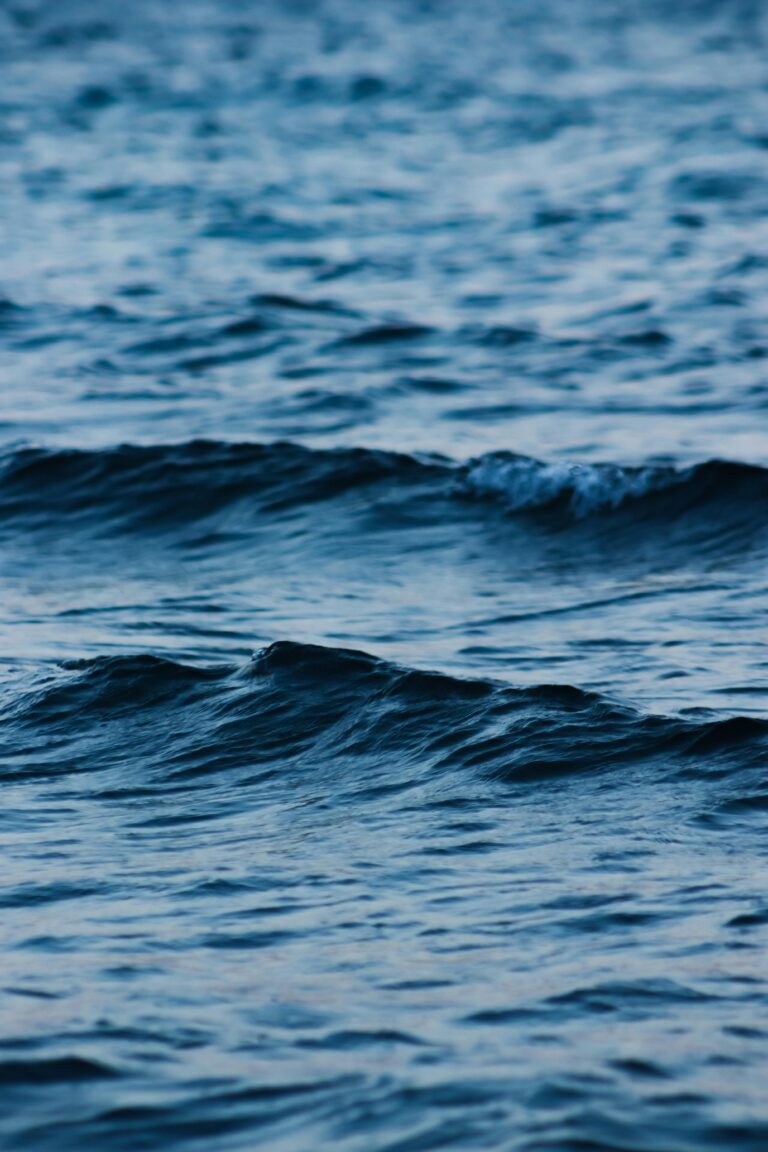 Captivating image of gentle ocean waves with a serene blue hue, perfect for calming visual projects.