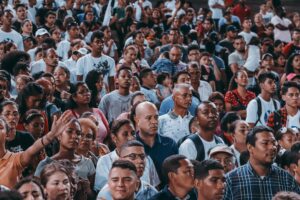A large, diverse crowd gathers outdoor, showcasing unity and community spirit.